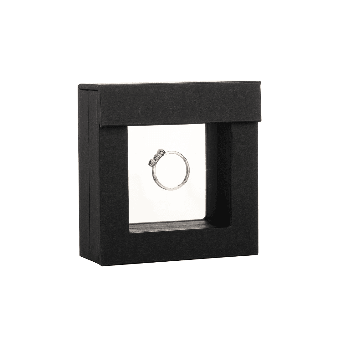 Sophisticated black display case showcasing a silver ring with intricate detailing, suspended in a clear, floating frame for a modern and elegant presentation.