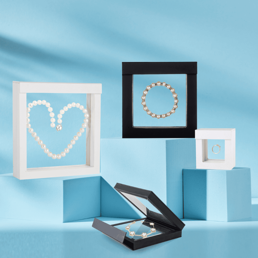 Circular image showcasing sustainable jewelry packaging, including cardboard boxes with cotton inserts in silver, gold, and kraft finishes, and an elegant gold box for necklaces. Set against a pink background with heart garlands, inviting users to shop eco-friendly packaging solutions.